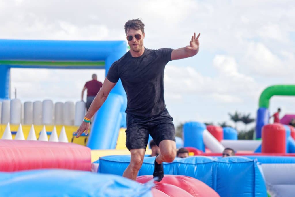 Man trying to balance on bouncy castle obstacle course