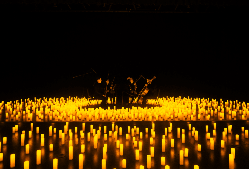 A string quartet performing a Candlelight concert surrounded by a sea of candles.