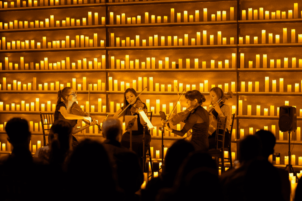 Four musicians performing by candlelight