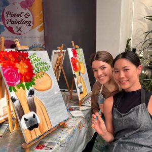 Two people with their works of art in a painting workshop