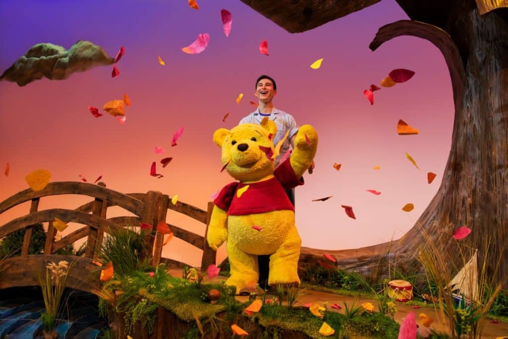 Winnie the pooh life-size puppet on stage with puppeteer